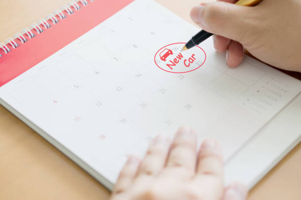 istock Hand writing in calendar plan and coins concept, new car 1163536537