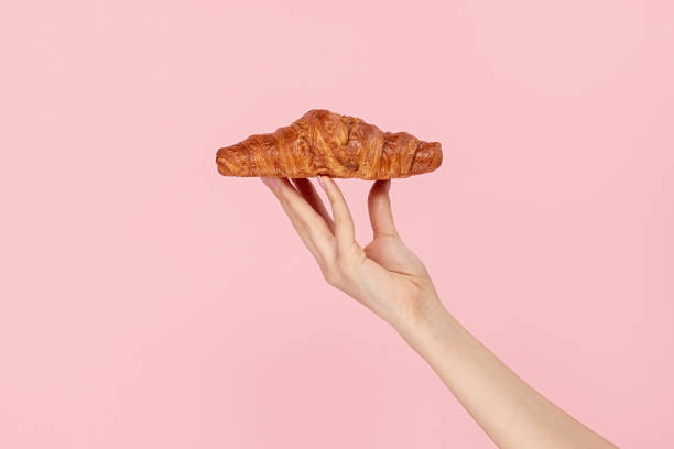 istock Woman presenting delicious pastry on pink background 1163537606