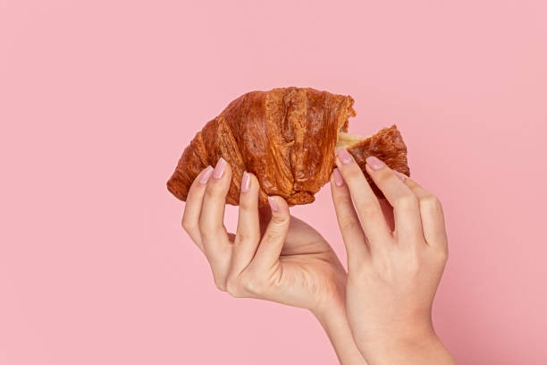 istock Crop girl tearing fresh soft croissant 1163537610