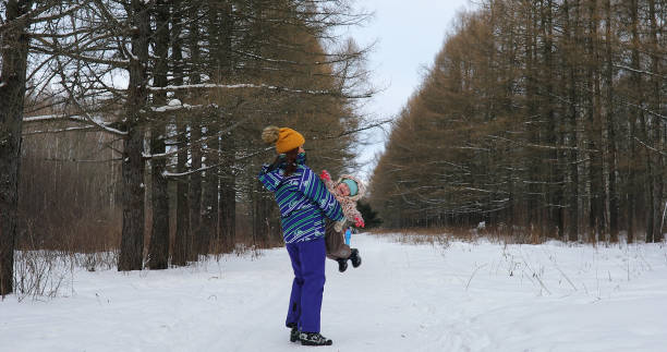 istock Parent holding kid on hands in winter park 1163537815
