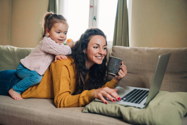 istock Mother and daughter using laptop on sofa 1163539460