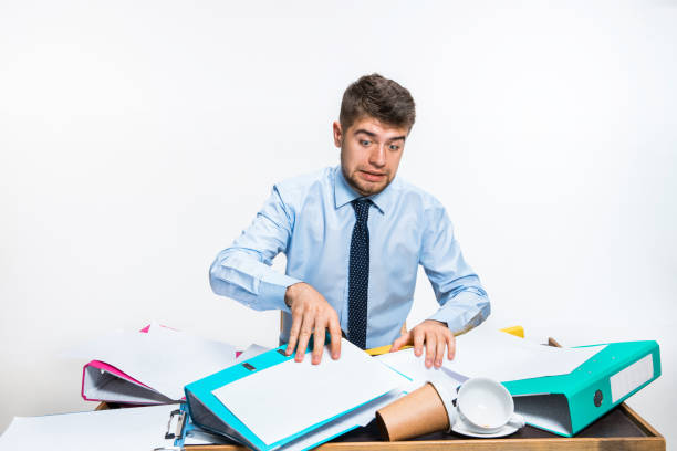 istock The young man has a complete mess in the workplace, he cannot organize his space 1163540145