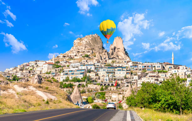 Uchisar castle, one of the most famous landmark in Turkey and one hot air balloon getting close to the castle. Uchisar castle, one of the most famous landmark in Turkey and one hot air balloon getting close to the castle. uchisar stock pictures, royalty-free photos & images