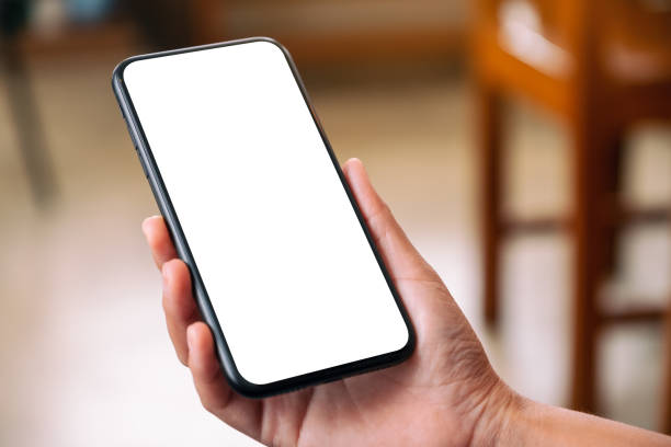 istock a hand holding black mobile phone with blank desktop screen 1163541745