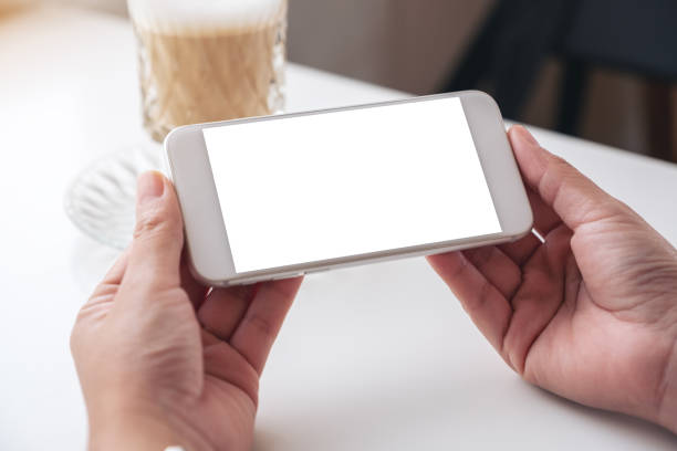 istock a woman holding white mobile phone with blank desktop screen 1163541758