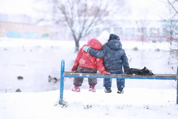 Photo of Kids walk in the park first snow