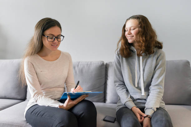 女の子ティーンエイジャー14、15歳女性心理学者と話す - 13 14 years 写真 ストックフォトと画像