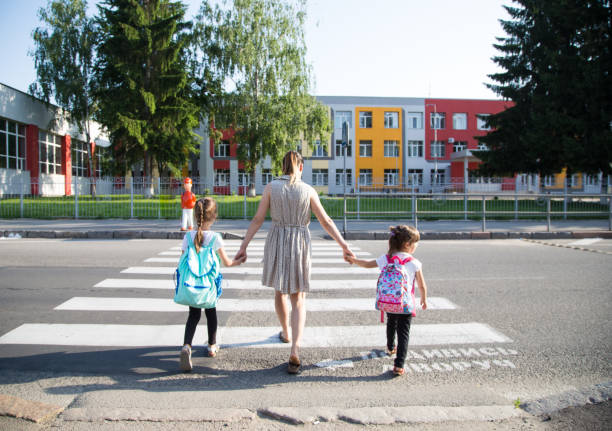 istock Back to school education concept with girl kids, elementary students, carrying backpacks going to class 1163544499