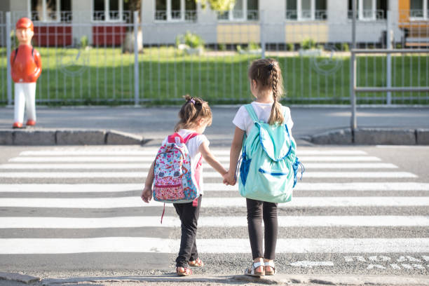 istock Back to school education concept with girl kids, elementary students, carrying backpacks going to class 1163544502