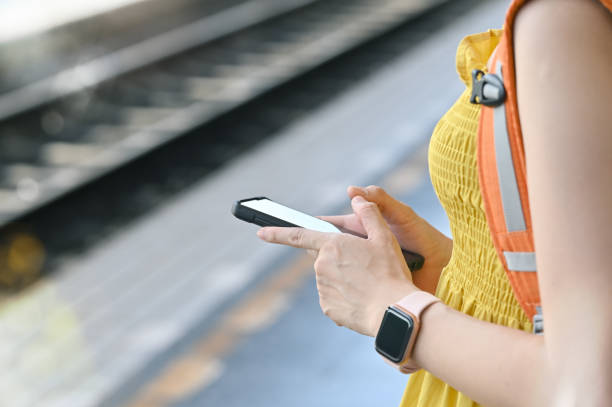 istock Cropped shot female using smart phone and waiting on train station. 1163544654