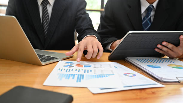 istock Consulting business with two man analysis finance data with device and paper document. 1163544668
