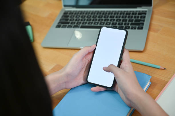 istock Mockup smartphone on woman's hands with office desk. 1163544715