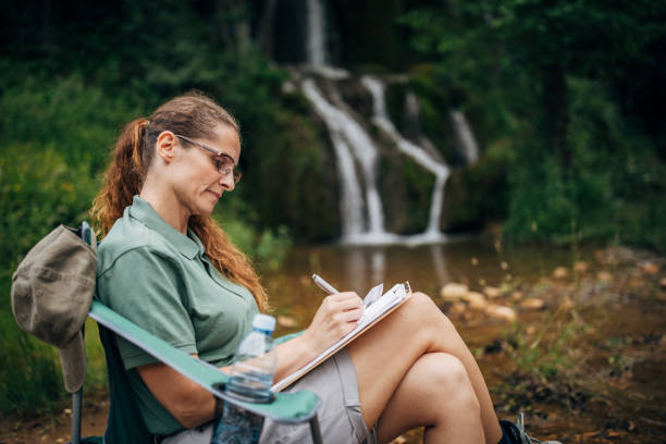 istock Woman biologist taking notes by the waterfall 1163544826