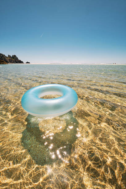 istock Blue rubber ring floating on the clear shallow idyllic sea at Pedn Vounder Beach, Cornwall on a perfect June day. 1163545653