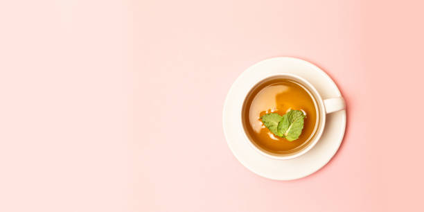 istock Creative concept of white ceramic cup with herbal green or black tea with mint leaves 1163547235