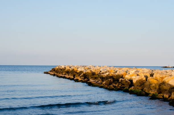 istock Stones  wave breaker  and  sea against  sunset  blue sky  during summer . 1163548263