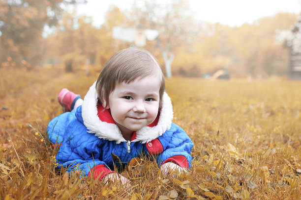 istock Little girl posing on camera walking in autumn park 1163550954