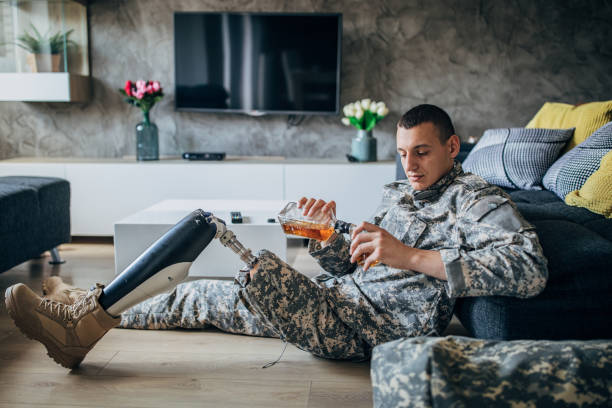 istock Depressed soldier with amputee leg drinking alcohol 1163554254