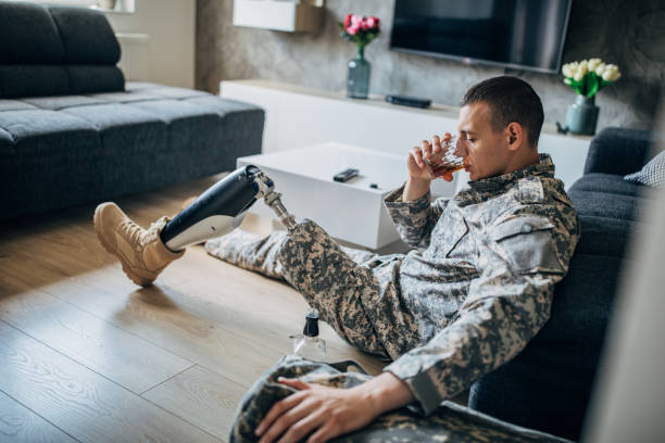 istock Depressed soldier with amputee leg drinking alcohol 1163554329