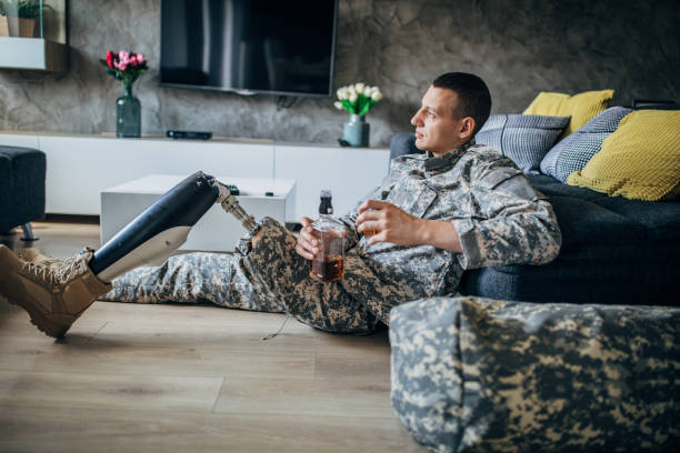 istock Depressed soldier with amputee leg drinking alcohol 1163554357