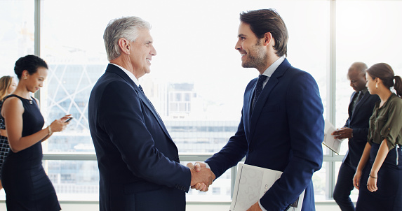 Cropped shot of two businessmen shaking hands in an office