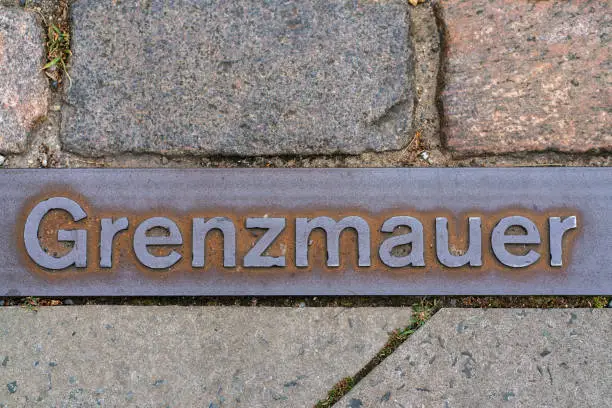 Photo of Metal plate on a walkway in Berlin indicating where the Berlin wall stood