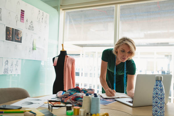 istock Female fashion designer using laptop at desk 1163560285