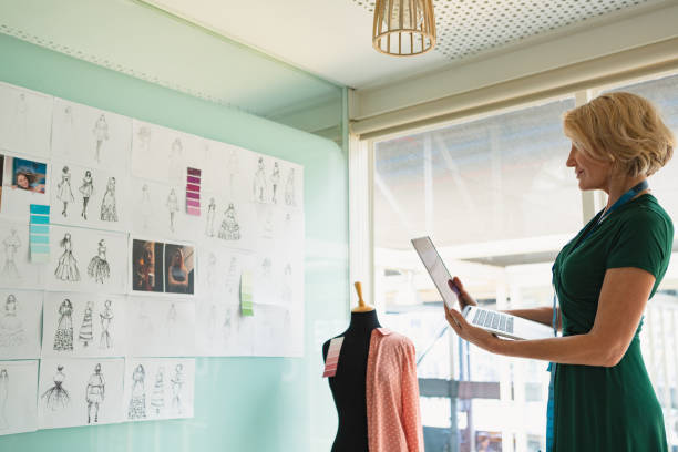 istock Female fashion designer using laptop in design studio 1163560298