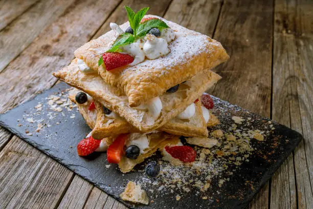 millefeuille with strawberries on wooden table