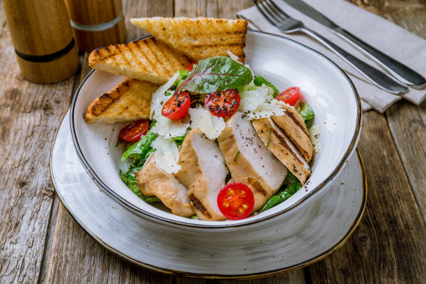 istock Salad caesar with chicken on wooden table 1163563054