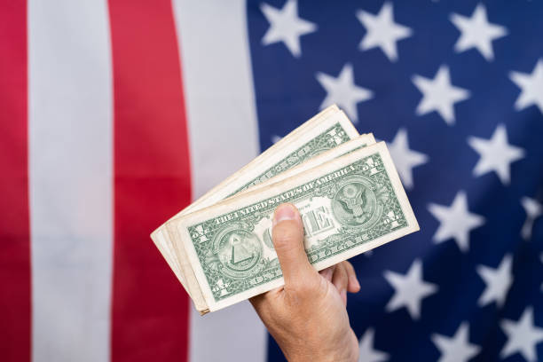 istock Hand holding dollar with America flag background 1163563166