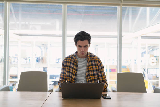 istock Male executive using laptop in the conference room 1163564182