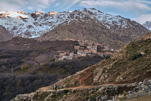 A view of sunset and touristic path in rural mountain village in High Atlas mountains Morocco Africa with snow covered peaks
