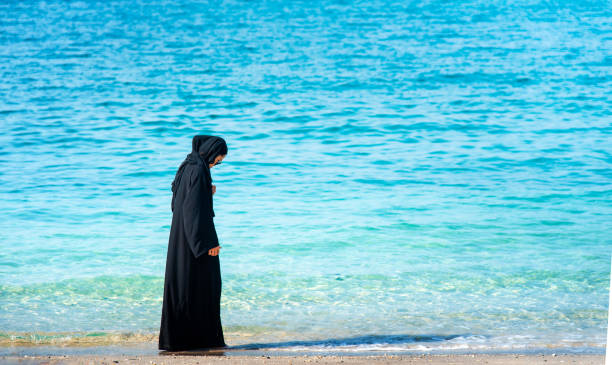 istock Muslim woman on the beach back view 1163566899