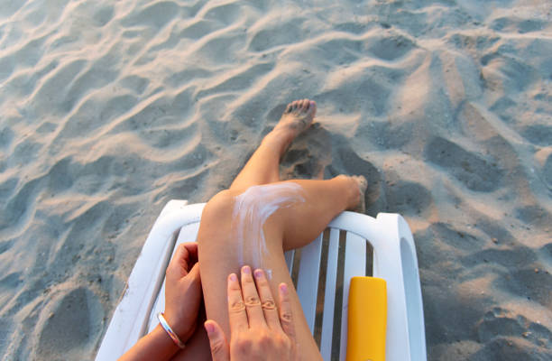 Woman using sun lotion on the beach