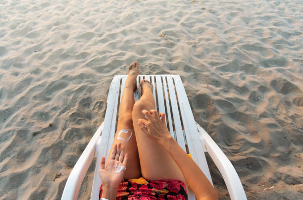 istock Woman using sun lotion on the beach 1163567250