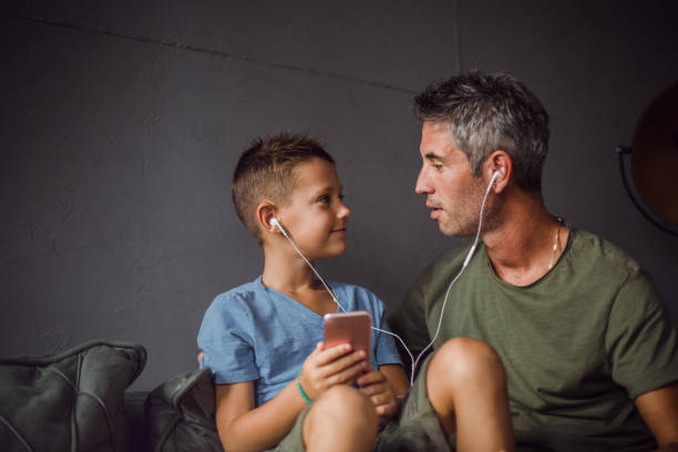 Father and son listening music stock photo
