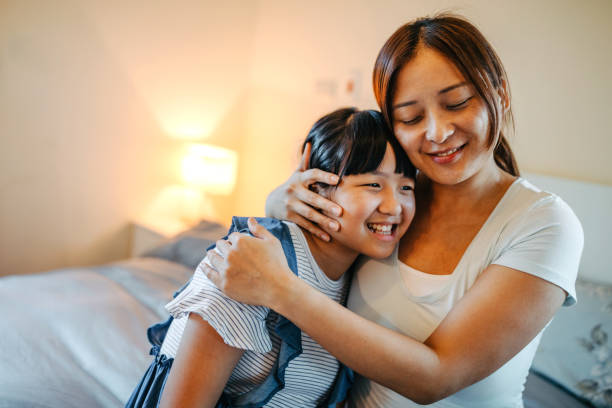 istock Mother sitting on bed hugging daughter 1163568610