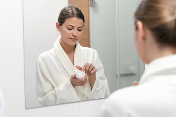 istock Woman holding cream in hands, standing at bathroom 1163569849