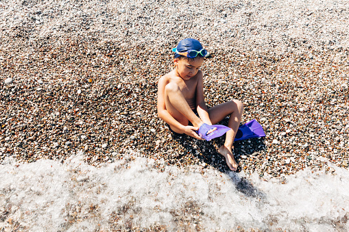 Child wearing palettes in beach