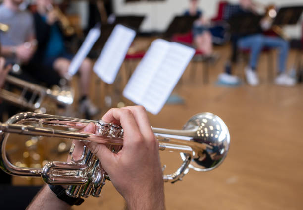 trumpet playing at a school rehearsal trumpet being played during a rehearsal session showing close ups of instrument secondary school activities stock pictures, royalty-free photos & images