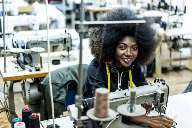 istock Female manual worker using sewing machine in factory 1163575180