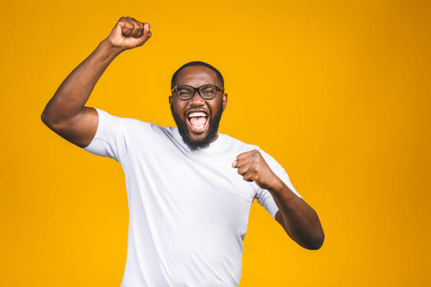 verticale du jeune mâle afro-américain excité criant dans le choc et l'étonnement. homme étonné semblant impressionné, ne peut pas croire sa propre chance et succès - excitation photos et images de collection