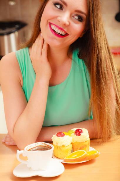 istock Woman with coffee cup cupcake in kitchen 1163576718