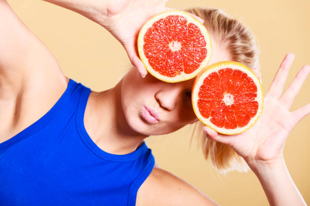 istock Woman holding grapefruit citrus fruit in hands 1163577869