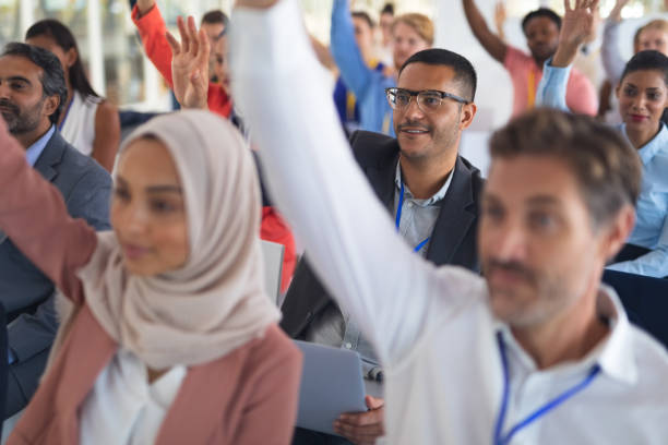 istock Audience raising their hands in a business conference 1163577954