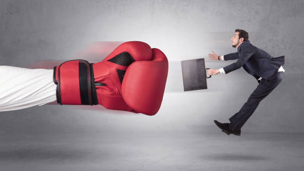 istock Businessman gets a hit from a giant hand 1163579175