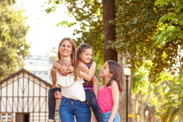 istock Happy mother and daughters having fun outdoors 1163579480