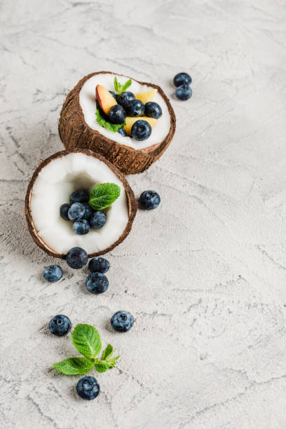 Fresh blueberries and peaches with mint bowl of coconut