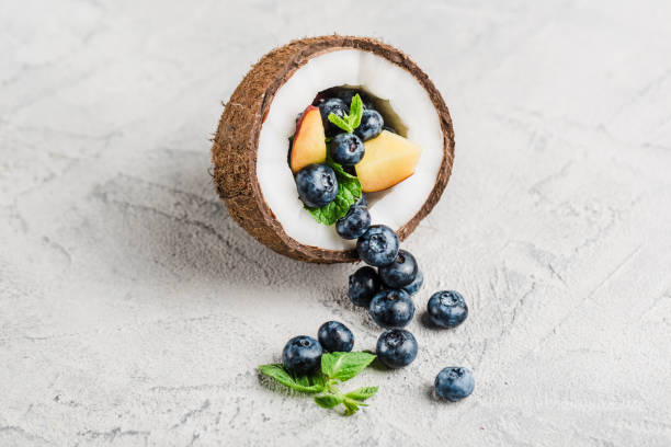 Fresh blueberries and peaches with mint bowl of coconut